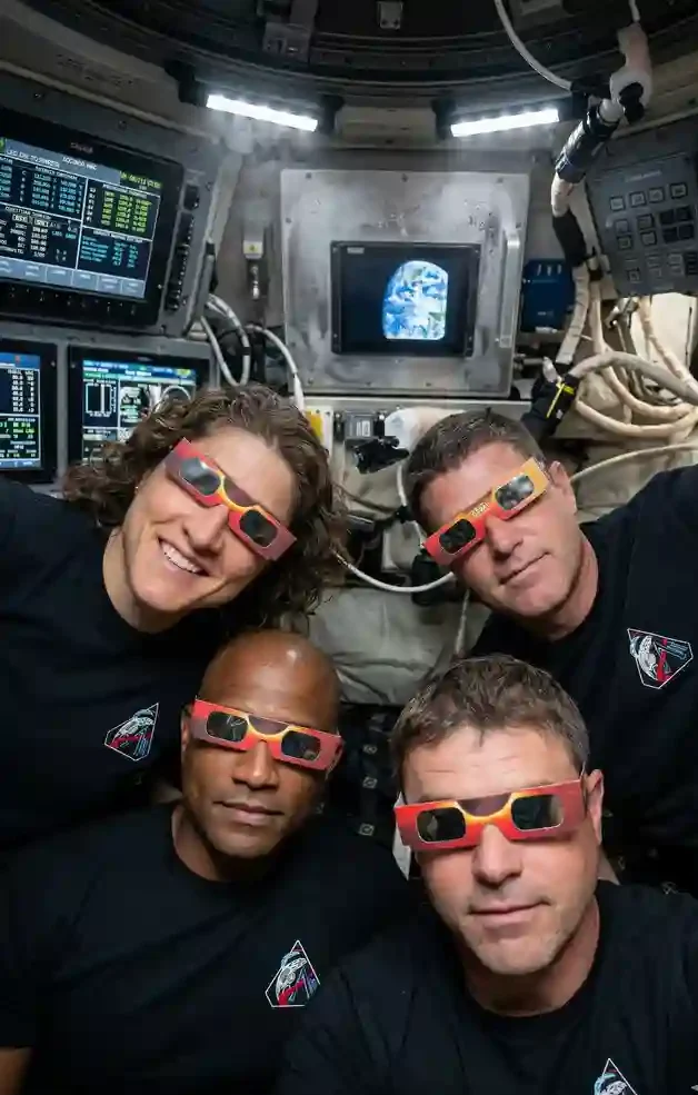 Humanityβs Frontline: The Artemis II Crew Empat astronot Artemis II (Reid, Victor, Christina, Jeremy) berfoto selfie menggunakan kacamata pelindung di dalam kabin Orion.